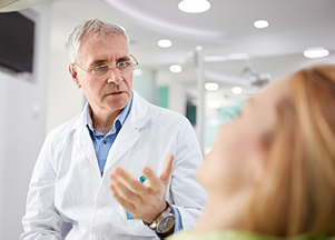 Image of a dental professional discussing veneers vs dental crowns with a patient, at The Center for Esthetic Dentistry in Grants Pass, OR.