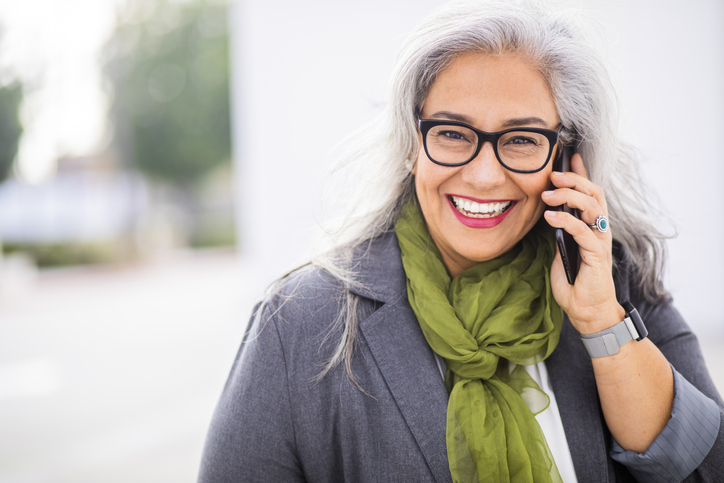A smiling patient contacting The Center for Esthetic Dentistry on a cell phone in Grants Pass, OR.