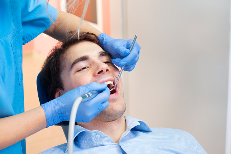 Man receiving dental cleaning from dental hygienist, at The Center for Esthetic Dentistry in Grants Pass, OR.