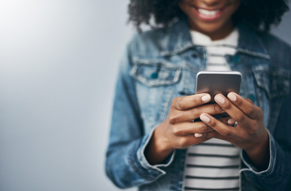 Woman looking at website on her phone in her Grants Pass, OR home.