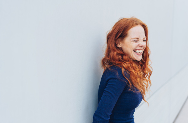Woman leaning againtst wall and smiling